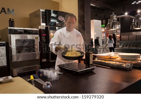 MILAN, ITALY - OCTOBER 18: A cook prepares food at Host 2013, international exhibition of the hospitality industry on OCTOBER 18, 2013 in Milan.