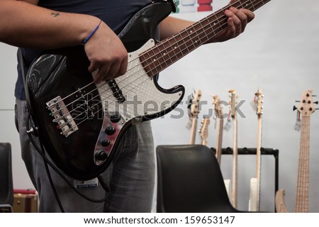 MILAN, ITALY - OCTOBER 20: Musician plays bass guitar at Milano Guitars & Beyond 2013, important trade show of string instruments with specific attention to guitars on OCTOBER 20, 2013 in Milan.