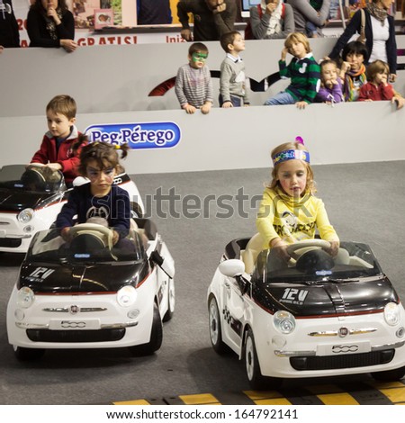 MILAN, ITALY - NOVEMBER 22: Children drive electric cars at G! come giocare, trade fair dedicated to games, toys and children on NOVEMBER 22, 2013 in Milan.