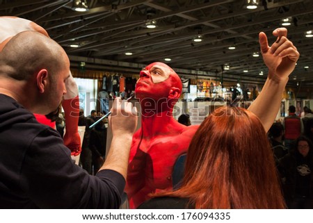 MILAN, ITALY - FEBRUARY 8: Bodybuilder during body painting session at Milano Tattoo Convention, international event dedicated to tattoos, body piercing and body painting on FEBRUARY 8, 2014 in Milan.