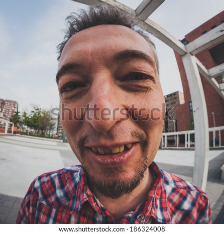 Distorted portrait of a man with goatee standing outdoor