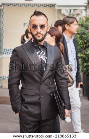 MILAN, ITALY - SEPTEMBER 20: Man poses outside Jil Sander fashion shows building for Milan Women\'s Fashion Week on SEPTEMBER 20, 2014 in Milan.