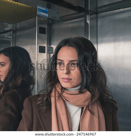 Beautiful young woman with long hair inside a lift