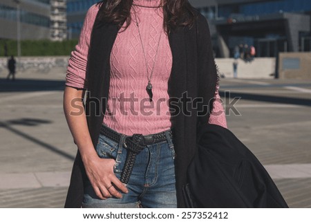 Detail of a beautiful young brunette with over the knee boots posing in the city streets