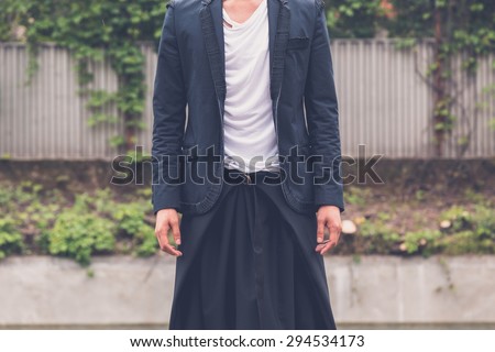 Detail of a young handsome Asian model dressed in black posing in the city streets