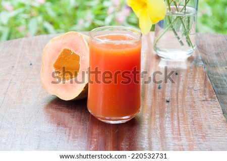 Papaya juice and papaya fruit on wood table