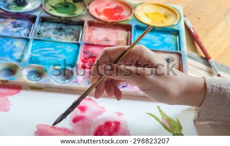 Artist is painting flower by watercolor on paper