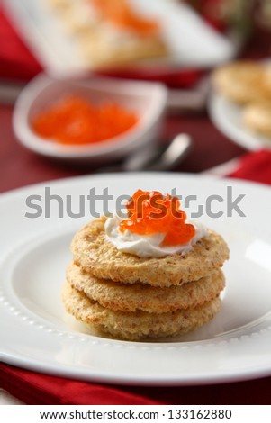 Oat bran cookies with red caviar and cream cheese
