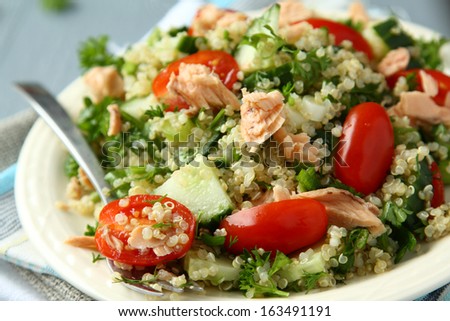 Tabbouleh salad with quinoa, salmon, tomatoes, cucumbers and parsley