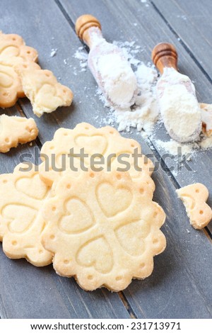 Homemade gluten free shortbread cookies with scoops of gluten free flour on old wooden background,  viewed from above