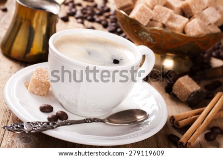 Espresso Coffee cup with Coffee pot, beans sugar sticks and milk jug . Inspirational early morning breakfast.