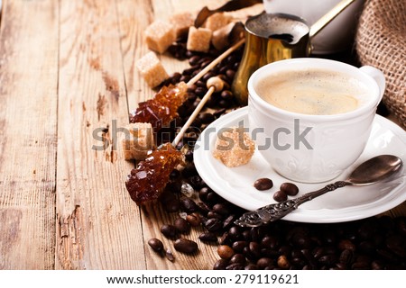 Espresso Coffee cup with Coffee pot, beans sugar sticks and milk jug . Inspirational early morning breakfast. Coffee background with copy space.