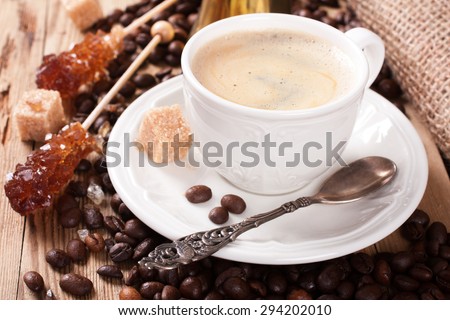 Espresso Coffee cup with Coffee pot, beans sugar sticks and milk jug . Inspirational early morning breakfast.