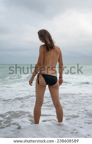 Young woman watching the sea and the waves
