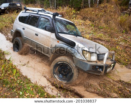NIZHNY TAGIL. RUSSIA - JUNE 12, 2013: Russian Plain Road in the heart of Siberia. Wheel drive vehicle leaves the swamp