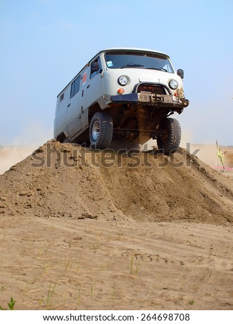 KUSHVA, RUSSIA - AUGUST 08, 2010: Auto racing trial in the sand pit. Four-wheel drive car jumps over the mountain of sand