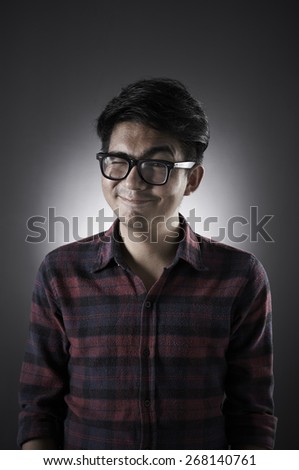 Asian male wearing glasses in low key with smart pose