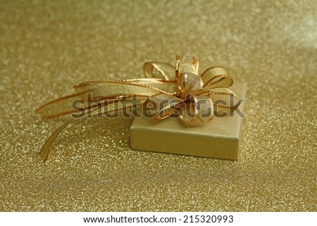 Christmas gift on Decorative background in gold with sparkling stars