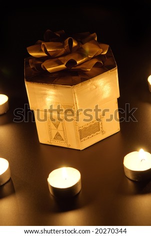 Christmas candle and gift box on black background