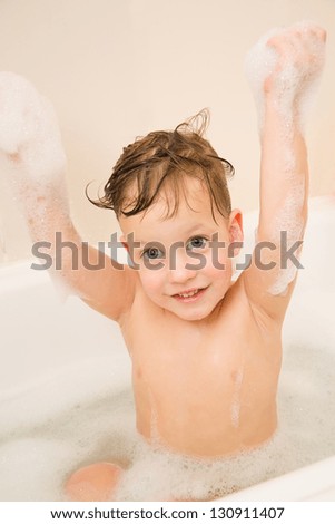 Cute three years boy taking a bath with foam