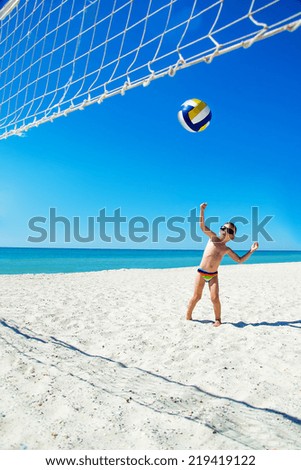 Kid play volleyball on sea beach, Ukraine