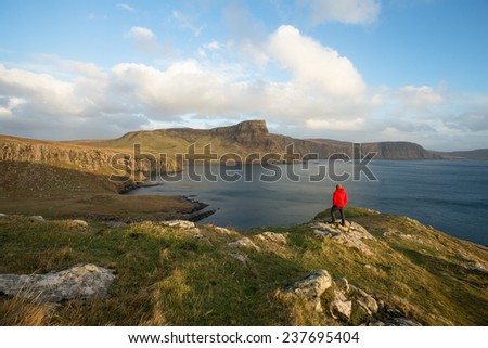 Man looking at view of impressive coastal cliffs on the Isle of Skye, Scotland