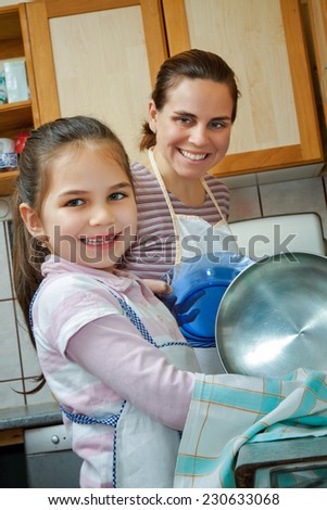 Little girl help her mother in kitchen
