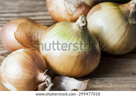 Close-up of golden onion bulbs  on a wooden background in the horizontal format
