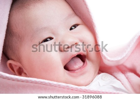 cute baby in pink blanket laughing happily