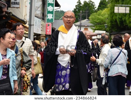Koya, Japan - June 14, 2011: Buddhist priest distributing good luck charms during Aoba festival, an annual event celebrating the birthday of Kobo Daishi, one of Japan's most renowned Buddhist saints