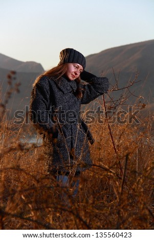 girl walking in bushes when sun going down