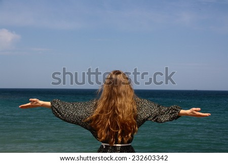 Beautiful girl watching sea and sky in happy mood