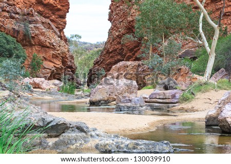 A Creek find his way through a deep red gap in the Red Center of Australia