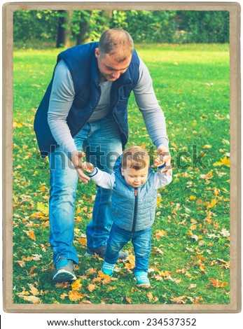 Family father  with child in park walking in same clothes textile jeans jacket. First step baby