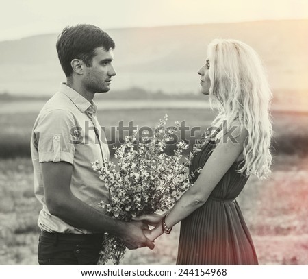 Happy people outdoors beautiful landscape and couple in love with flowers on sunset