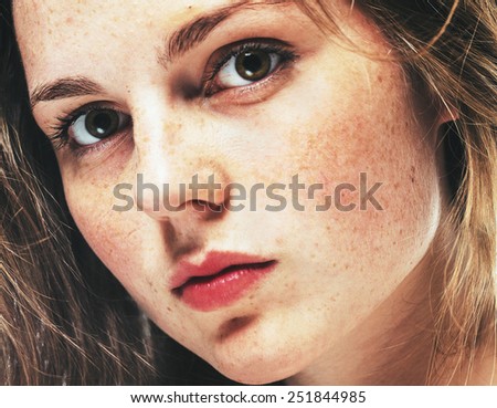 Close-up, beauty portrait of a brunette girl with beautiful lips and freckles