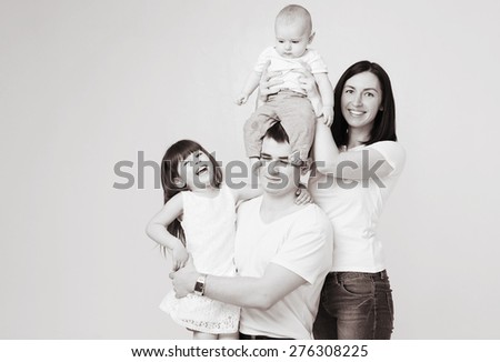 Happy beautiful family 4 people with new born baby parents sister brother portrait black and white