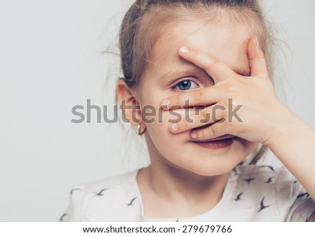 Pry Little cute girl closed face by hand