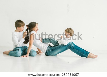 Family mother with children studio portrait full length in jeans on white background