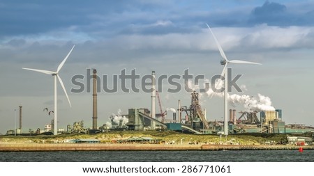 Windmills and old industrial area at the sea side. New and old technologies together shows a contrast in North Europe