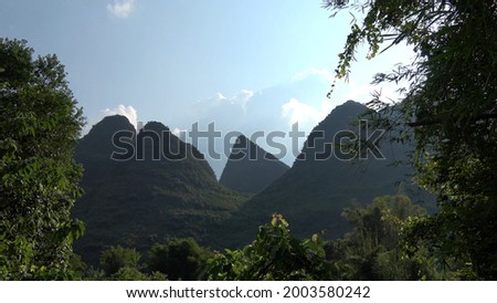 Zoom out view of karst peaks located at Chinese Yangshuo County in under the jurisdiction of Guilin City in the northeast of Guangxi Zhuang Autonomous Regio China bordered on one side by the Li River 商業照片 © 