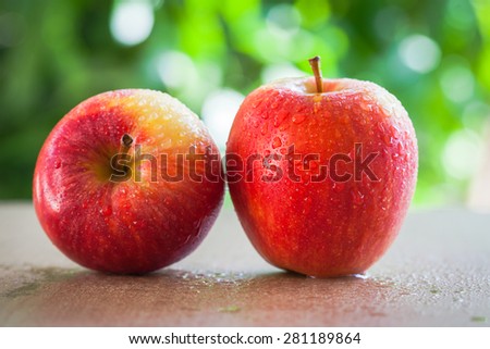 Red apple in natural light with blurred background effect of trees in the garden. image suitable for restaurants, supermarkets, wholesalers, resellers Dragon Fruit products or health products