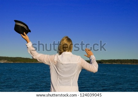 woman in front of the sea, waving to say goodbye