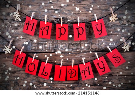 Red Tags with Happy Holidays on it Hanging on a Line on Wood with Snow, Christmas or Winter Holiday Greetings