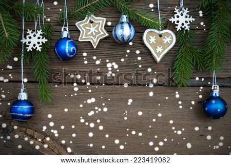 Christmas Balls, Fir Tree Branches, Snowflakes and Ginger Bread Cookies on Wood in the Snow with Copy Space