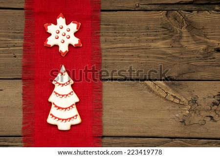 Red and white decorated Christmas Tree and Star Cookie on Red Drapery on Wooden Background with Copy Space
