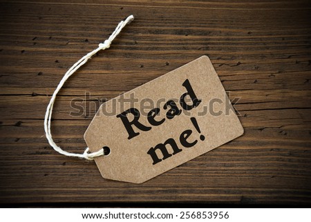 Close Up Of A Brown Label With White Ribbon On Wooden Background With English Text Read Me Frame And Vintage Or Retro Style