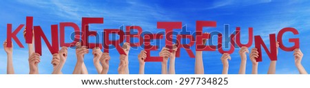 Many Caucasian People And Hands Holding Red Letters Or Characters Building The German Word Kinderbetreuung Which Means Child Care On Blue Sky