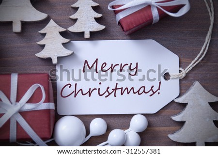 Black and White Close Up Of Label With Ribbon,Red Gift,Present, Ribbon And Tree. Christmas Decoration Or Card On Wooden Background. English Text Merry Christmas