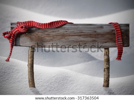 Brown Wooden Christmas Sign On White Snow. Snowy Scenery. Red Ribbon, Copy Space For Advertisement. Christmas Decoration Or Christmas Card. Rustic Or Vintage Syle.